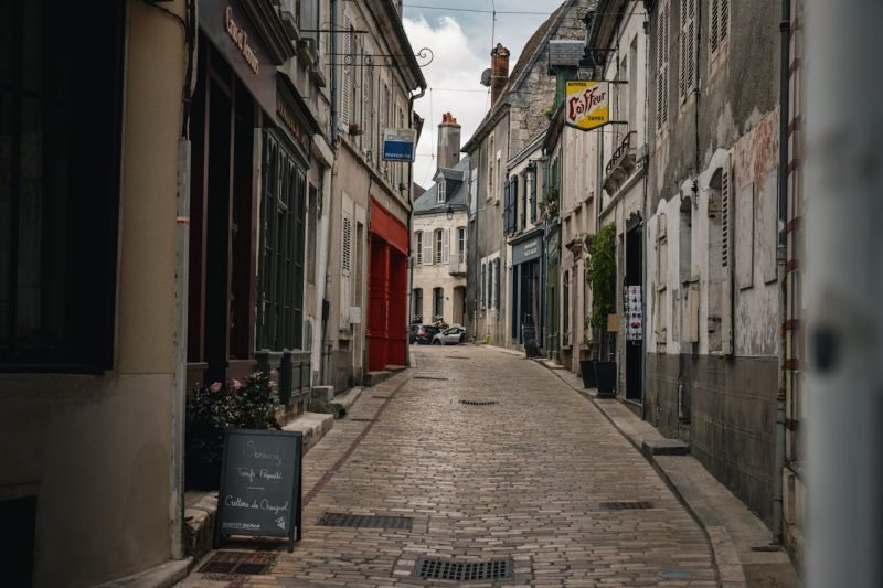 Explore a picturesque cobblestone street in Sancerre, France, showcasing historic architecture and cozy cafes.